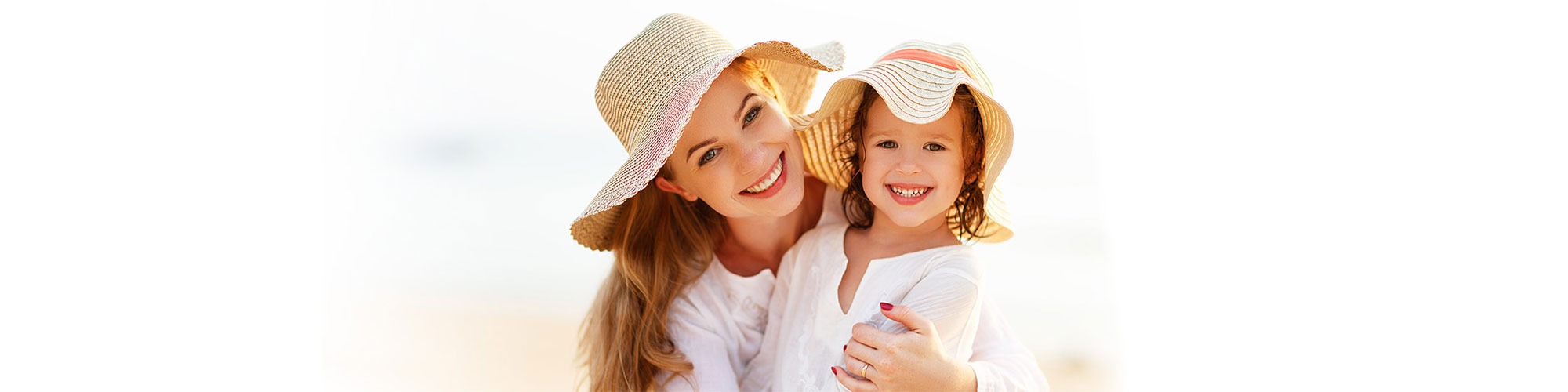 Woman on the beach holding her child smiling